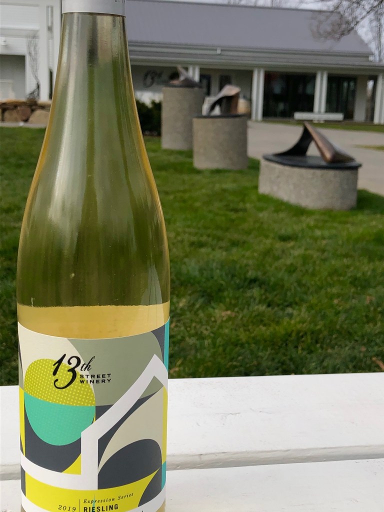 bottle of 13th street Riesling in front of winery