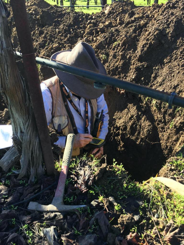 Deep soil pit with man inside measuring content