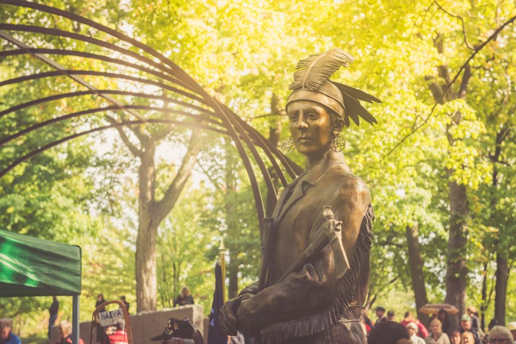 a bronze statue of a famous Indigenous warrior and chief in headress and carrying a tomahawk who helped lead his troops to battle during the war of 1812 