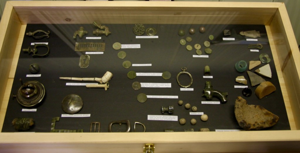 a showcase of military relics from the war of 1812 dug up in the vineyard