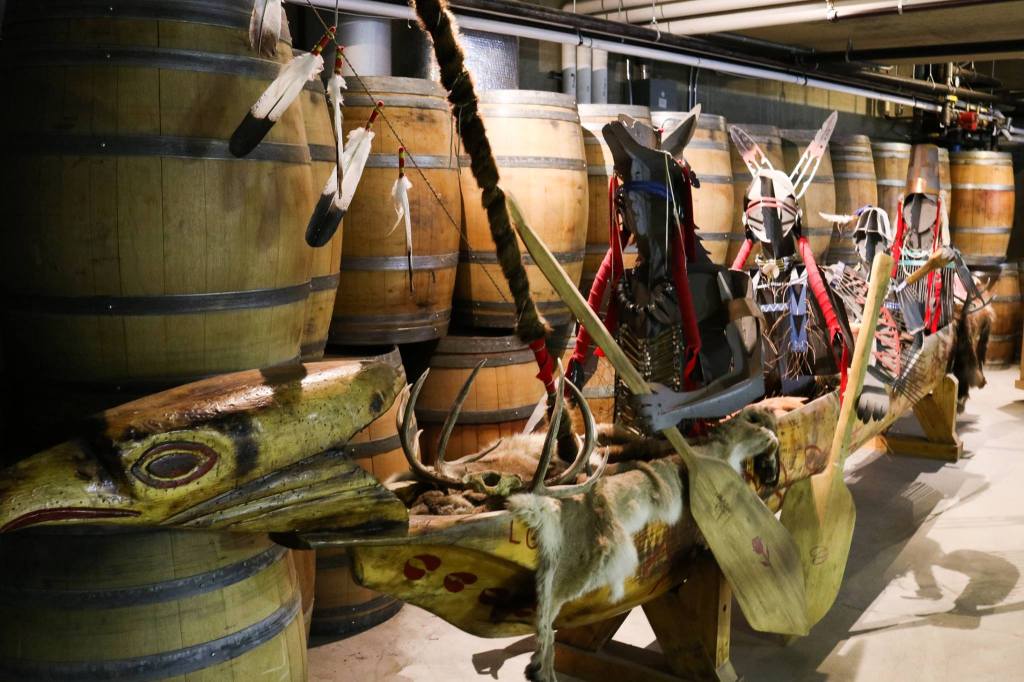 winery with barrels and First Nation's sculpture featuring a hardwood canoe with four metal sculpture Indigenous warriors